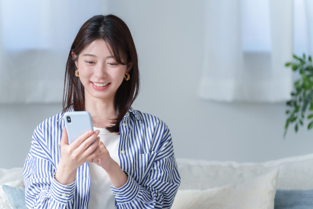 スマホで出会い系サイトを使う笑顔の女性