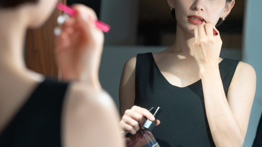 鏡を見ながらメイクをする女性——女性側もプロフィールをしっかり見ている