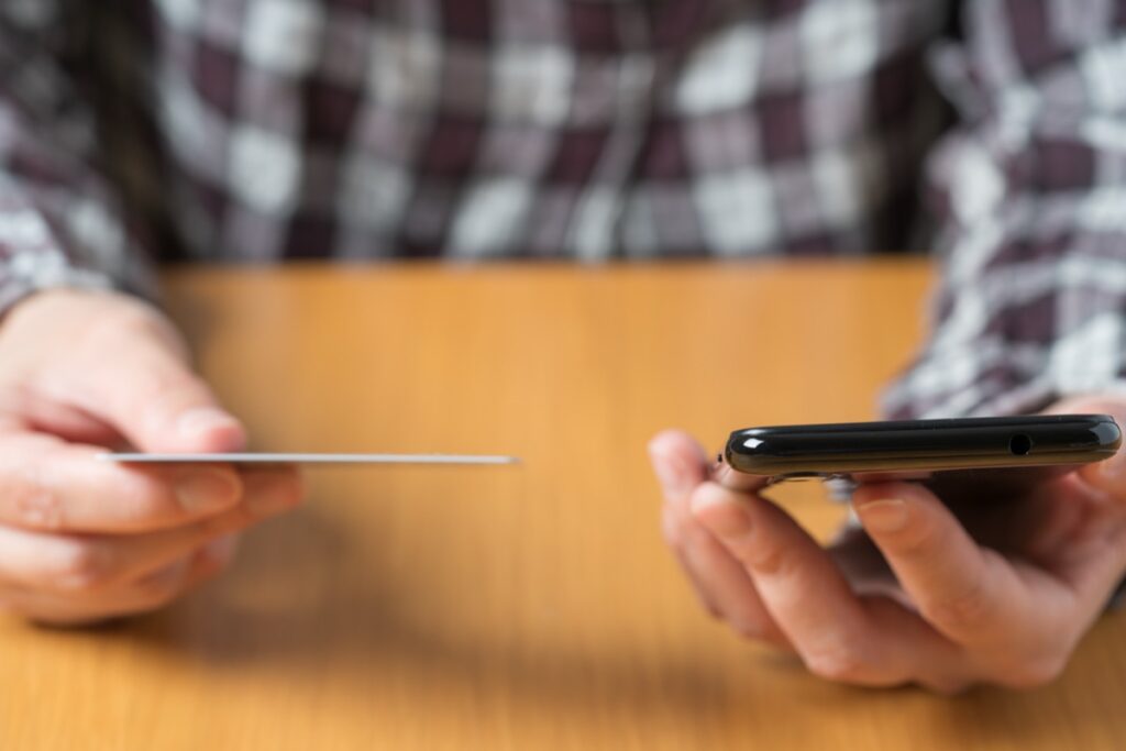 スマホでチャットアプリのポイントを購入する男性の手元